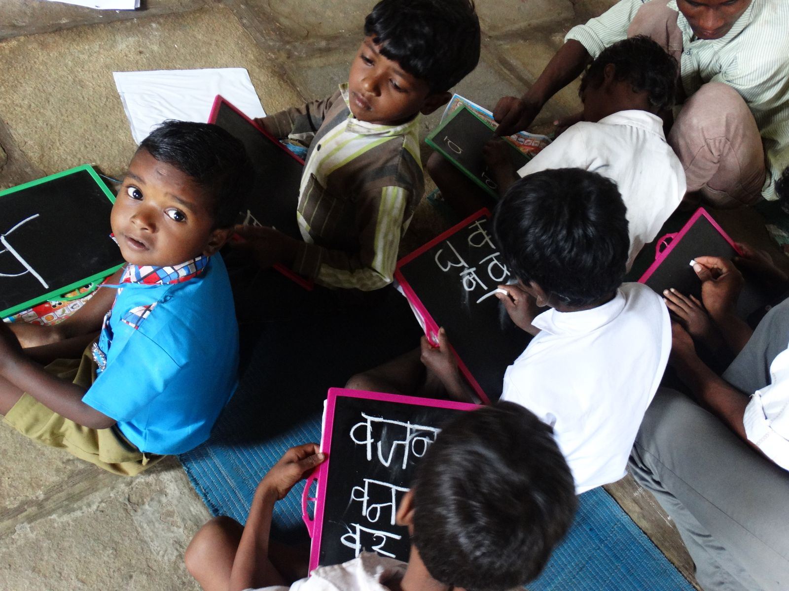 Children writing on slates in a village school in India