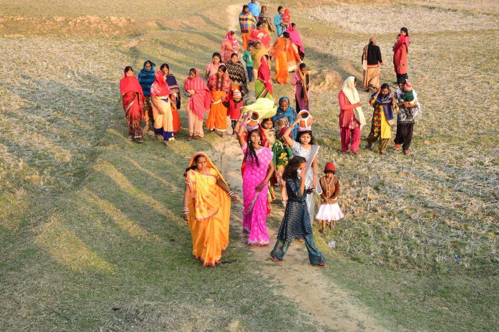 Women in colourful sarees working in a field